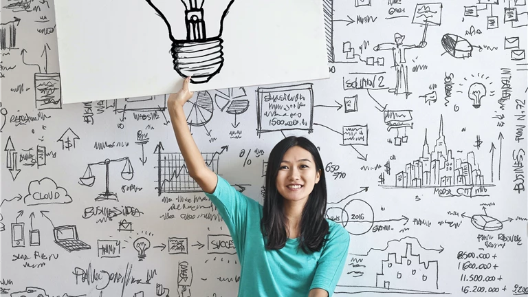 Woman Draw a Light bulb in White Board